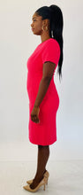 Load image into Gallery viewer, A side view of a size 14 Black Halo for 11Honoré hot pink cap sleeve short sleeve midi sheath dress styled with sleek tan pumps on a size 12 model.
