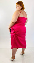 Load image into Gallery viewer, Full-body back view of a size 22 Pretty Little Thing hot pink strappy midi dress with a high side slit and structured boning at the bust styled with white heels on a size 22 model.
