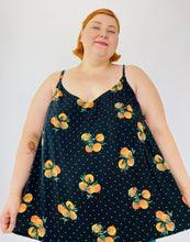 Load image into Gallery viewer, A size 4 Torrid black flowy tank top with an orange pattern and white mini polka dots on a size 22 model. The straps are adjustable.
