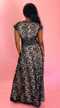 Load image into Gallery viewer, Full-body back view of a size 12 Monique Lhuillier for 11 Honoré cream with black floral lace v-neck gown with stripe details and cap sleeves on a size 10/12 model.
