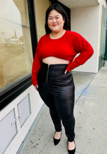 Load image into Gallery viewer, Full-body front view of a Bloomchic crew neck long sleeve top with gathering at the neckline and bell cuffs styled tucked up into a crop over black pleather pants on a size 14/16 model.
