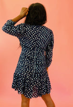Load image into Gallery viewer, Back view of a size 14 Tanya Taylor for 11HONORÉ navy blue long sleeve mini dress with light blue, and metallic silver swiss dot sheer overlay, ruffles and gathering, and a high neck on a size 10/12 model.
