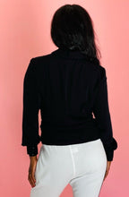 Load image into Gallery viewer, Back view of a size 14 Zac Posen for 11 Honoré black pleated button-front western style blouse with subtle balloon sleeves styled with white tapered pants on a size 12 model.
