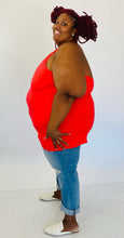 Load image into Gallery viewer, Full-body side view of a size 6 Torrid coral red v-neck halter tank styled with light wash jeans and white slides on a size 26/28 model.
