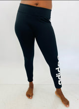 Load image into Gallery viewer, Front view of a pair of size XL Adidas black active leggings with the &quot;Adidas&quot; logo down the side on a size 12 model.
