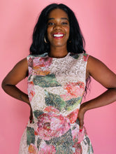 Load image into Gallery viewer, Closer view of the high-necked bodice of a size 14 Monique Lhuillier for 11 Honoré white lace a-line mini dress with pink and green floral pattern and a voluminous skirt on a size 12 model.
