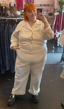 Load image into Gallery viewer, Additional full-body front view of a size 5X Big Bud Press off-white collared boiler suit/jumpsuit with zip-front details styled with black mary janes on a size 22/24 model
