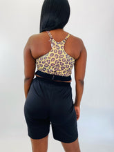 Load image into Gallery viewer, Back view of a size XXL Adam Selman yellow and brown leopard print sports bra styled with black mesh shorts on a size 12 model.
