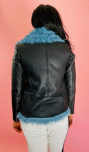 Load image into Gallery viewer, Back view of a size L VEDA black leather jacket with baby blue shearling fur on the inside styled over a black top and white pants on a size 10/12 model.
