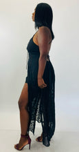 Load image into Gallery viewer, Full-body side view of a stunning size 14 Showpo. black lace-up criss-cross detail shorts romper with star-printed sheer black mesh maxi overlay styled with maroon strappy heels on a size 12 model.
