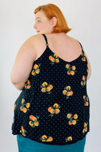 Load image into Gallery viewer, Back view a size 4 Torrid black flowy tank top with an orange pattern and white mini polka dots on a size 22 model. The straps are adjustable.
