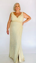 Load image into Gallery viewer, Additional full-body front view of a size 20 La Femme Curve shimmery champagne yellow gown with a faux wrap bust and high side slit styled with tan pumps on a size 18/20 model.
