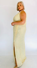 Load image into Gallery viewer, Full-body side view of a size 20 La Femme Curve shimmery champagne yellow gown with a faux wrap bust and high side slit styled with tan pumps on a size 18/20 model.
