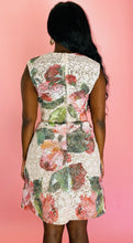 Load image into Gallery viewer, Back view of a size 14 Monique Lhuillier for 11 Honoré white lace a-line mini dress with pink and green floral pattern, a high neck, and a voluminous skirt styled with tan pumps on a size 12 model.
