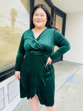Load image into Gallery viewer, Front view of a size 16 Bloomchic green velvet midi dress with tulip hem and long sleeves on a size 14/16 model.
