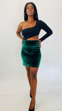 Load image into Gallery viewer, Full-body front view of a size 1X Fashion Nova black one-shoulder long sleeve crop top styled with a green velvet bodycon mini skirt and black pumps on a size 12 model.
