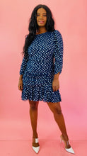 Load image into Gallery viewer, Full-body front view of a size 14 Tanya Taylor for 11HONORÉ navy blue long sleeve mini dress with light blue, and metallic silver swiss dot sheer overlay, ruffles and gathering, and a high neck styled with white heels on a size 10/12 model.
