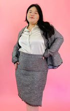Load image into Gallery viewer, Front view of a size 18 Lela Rose gray tweed, textured blazer and skirt 2-piece suit set with black unfinished fringe hem styled with an off-white button-up top on a size 14/16 model.

