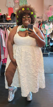 Load image into Gallery viewer, Additional full-body front view of a FTF Lab x La&#39;Tecia Thomas cream-colored textured halter maxi dress with a high-high side slit styled with silver sneakers and bold earrings on a size 22/24 model.
