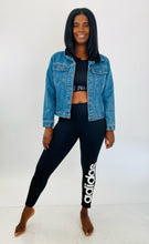 Load image into Gallery viewer, Full-body front view of a pair of size XL Adidas black active leggings with the &quot;Adidas&quot; logo down the side styled with a black sports bra and medium wash denim jacket on a size 12 model.

