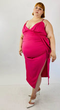 Load image into Gallery viewer, Full-body half-front view of a size 22 Pretty Little Thing hot pink strappy midi dress with a high side slit and structured boning at the bust styled with white heels on a size 22 model.
