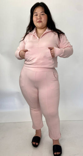 Full-body front view of a size 1 11 Honoré baby pink two-piece lounge set sold as is with some pen marks styled with black slides on a size 14/16 model.