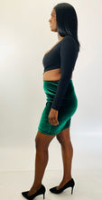 Load image into Gallery viewer, Full-body side view of a size 1X Fashion Nova black one-shoulder long sleeve crop top styled with a green velvet bodycon mini skirt and black pumps on a size 12 model.
