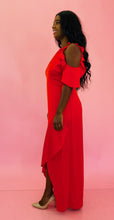 Load image into Gallery viewer, Full-body side view of a size 12 Monique Lhuillier for 11 HONORÉ vibrant red ruffled maxi with asymmetrical tulip hem, cold-shoulders, and keyhole bust detail styled with tan pumps on a size 10/12 model.
