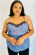 Load image into Gallery viewer, Front view of a size 2X Savage x Fenty light blue &quot;denim&quot; patterned camisole with black lace bust detail styled with black pants on a size 18 model.
