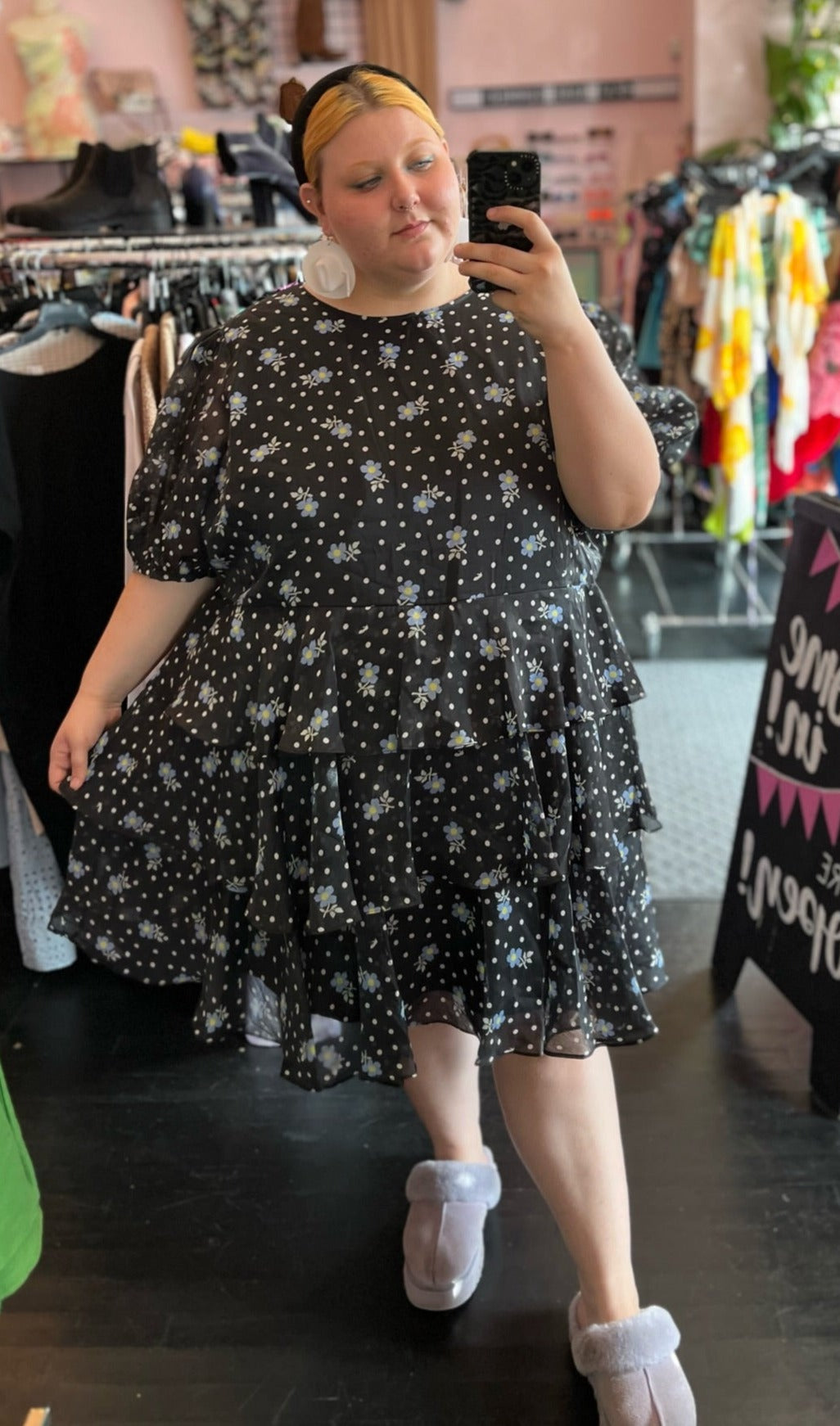Full-body front view of a size 4X Sandy Liang x Target collab black tiered midi dress with mini white polka dots and blue and yellow flowers styled with white earrings and a black headband on a size 22/24 model.