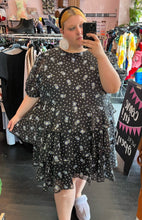 Load image into Gallery viewer, Front view of a size 4X Sandy Liang x Target collab black tiered midi dress with mini white polka dots and blue and yellow flowers styled with white earrings and a black headband on a size 22/24 model.
