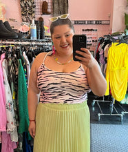 Load image into Gallery viewer, Front view of a size 2X Forever 21 pink, black, and white tiger stripe cropped tank styled with a lime green pleated skirt on a size 16 model.

