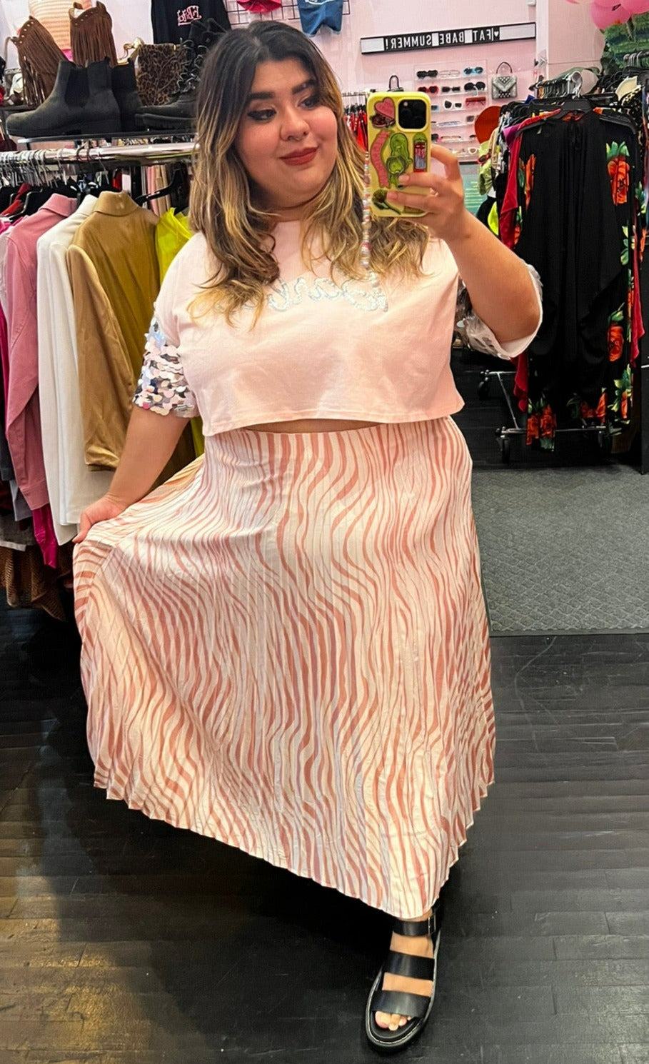 Full-body front view of a size 22 Eloquii cream and pink zebra print pleated maxi skirt styled with a baby pink crop top on a size 18/20 model.
