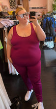 Load image into Gallery viewer, Closer full-body front view of a size 3X J. Dow Fitness magenta athletic jumpsuit styled with white sneakers and white block sunglasses on a size 22/24 model.
