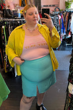 Load image into Gallery viewer, Front view of a size XL French Affair baby pink &quot;Please Stay 6 Feet Away&quot; graphic cropped tank styled under a yellow button up with a blue mini skirt on a size 22/24 model.
