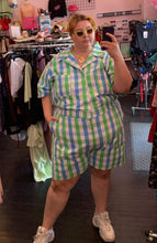 Load image into Gallery viewer, Full-body front view of a size 6X Big Bud Press green and blue checkered plaid short sleeve romper styled with white sneakers and an egg pendant on a size 22/24 model.
