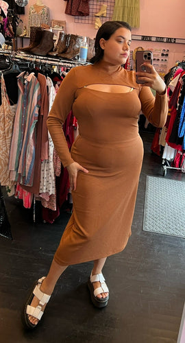 Full-body front view of a size XL Who What Wear warm-tone brown long sleeve bodycon maxi dress with mockneck and bust cutout detail styled with platform sandals on a size 14/16 model.