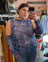 Load image into Gallery viewer, Close-up view of a size 18 ASOS blue, black, and white glitched plaid pattern futuristic-style mesh top with extreme cold shoulder and arm-warmer detail styled with jeans on a size 16 model.
