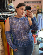 Load image into Gallery viewer, Close-up view of a size 18 ASOS blue, black, and white glitched plaid pattern futuristic-style mesh top with extreme cold shoulder and arm-warmer detail styled with jeans on a size 16 model.
