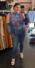 Load image into Gallery viewer, Full-body front view of a size 18 ASOS blue, black, and white glitched plaid pattern futuristic-style mesh top with extreme cold shoulder and arm-warmer detail styled with medium-wash denim and braided heels on a size 16 model.
