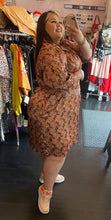 Load image into Gallery viewer, Full-body side view of a size 22W Eva Franco pink, maroon, orange, and green geometric print collared midi dress styled with sneakers on a size 20/22 model.
