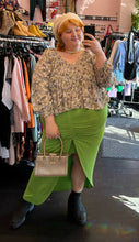 Load image into Gallery viewer, Additional full-body front view of a size 20 Eloquii bright lime green mini-maxi skirt with ruching and a high-low tulip hem styled with a ruffled blouse, cream beret, and gold purse on a size 22/24 model.
