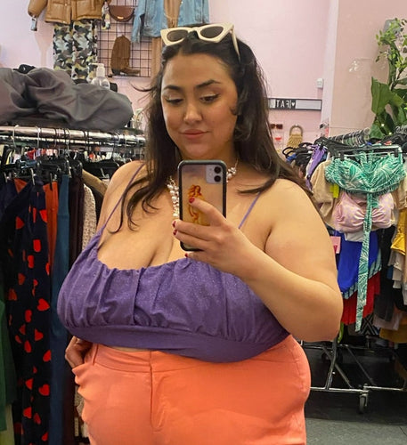 Front view of a size 4X Wild Fable purple sparkly spaghetti-strap crop top styled with peach trousers on a size 22/24 model.