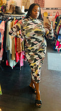 Load image into Gallery viewer, Additional full-body front view of a size XL Hugo green, yellow, and tan camo long sleeve mockneck bodycon maxi dress styled with black slides on a size 14/16 model.
