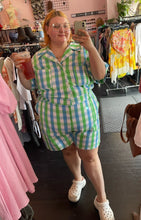 Load image into Gallery viewer, Full-body front view of a size 6X Big Bud Press green and blue checkered plaid short sleeve romper styled with white Crocs on a size 22/24 model.

