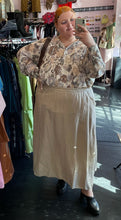 Load image into Gallery viewer, Additional full-body front view of a size XXL The Lullaby Club neutral tone floral blouse with fabric buttons, puff sleeves, and a baby doll shape styled tucked into a khaki elastic waist skirt on a size 22/24 model.
