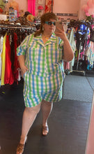 Load image into Gallery viewer, Full-body front view of a size 6X Big Bud Press green and blue checkered plaid short sleeve romper styled with brown heels on a size 24 model.
