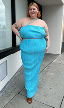 Load image into Gallery viewer, Full-body front view of a size 22 Pretty Little Thing aqua blue plisse pleated 2-piece crop and maxi skirt set styled with brown suede mules on a size 22/24 model. The photo is taken outside in natural lighting.
