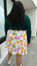 Load image into Gallery viewer, Back view of a size 2X Unicorn Tears vintage white midi skirt with pink, yellow, and green floral pattern styled with a deep emerald long sleeve top on a size 18/20. The photo is taken outside with natural lighting.
