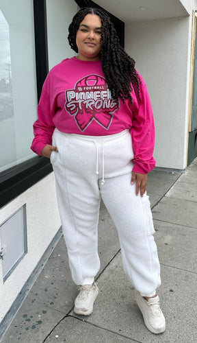 Full-body front view of a size 2X Adidas x Ivy Park white furry drawstring joggers styled with a pink long sleeve tee and white sneakers on a size 18/20 model.